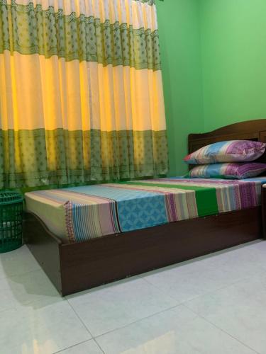 a bed in a room with a curtain and a bedskirtspectspectspectspects at Arrow in Vashafaru