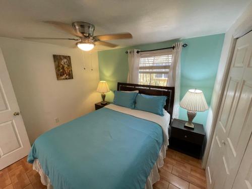 a bedroom with a blue bed and a window at 4BR Downtown House Near Beach, Pet Friendly in West Palm Beach