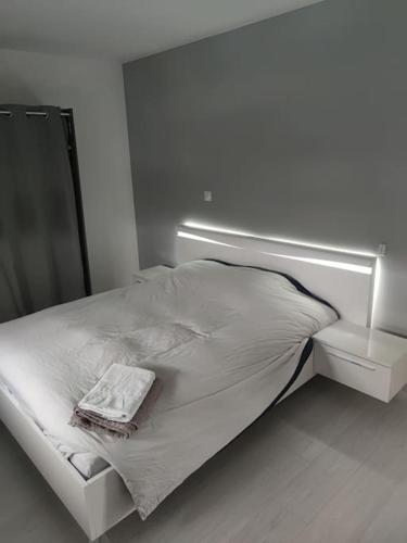 - un lit blanc dans une chambre blanche avec un miroir dans l'établissement magnifique villa avec piscine et spa, à Merville