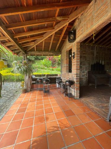 a patio with a stone floor and a wooden ceiling at Finca Hotel Tierra Verde in Girardota