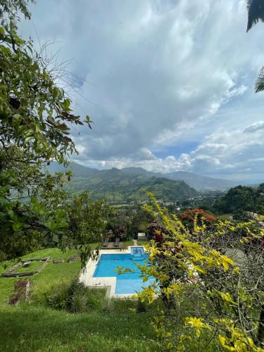 a view of a swimming pool with mountains in the background at Finca Hotel Tierra Verde in Girardota