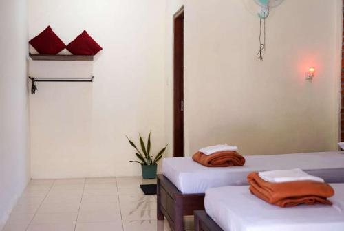 a room with two beds with towels on them at Penginapan Homestay Mudiyono Syari'ah in Borobudur