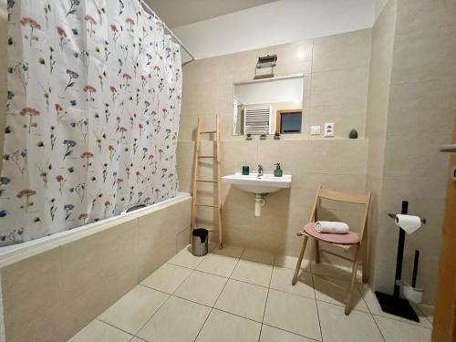 baño con lavabo y cortina de ducha en BL City View Luxury Apartment en Banská Bystrica