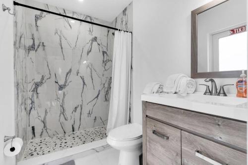 een badkamer met een douche, een toilet en een wastafel bij Modern Getaway 4BRs House with Pool and Game Room in Hollywood