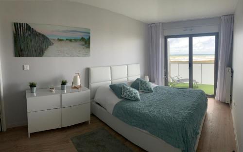 a bedroom with a bed and a large window at Face mer pieds dans l'eau in Berck-sur-Mer