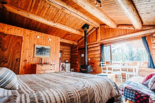 ein Schlafzimmer mit einem Bett in einem Blockhaus in der Unterkunft Rocky Mountain Escape Log Cabin Rentals - Rock Lake in Rock Lake Lodge Provincial Park