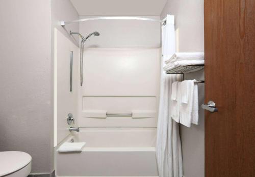 a white bathroom with a shower and a toilet at Super 8 by Wyndham Amarillo in Amarillo
