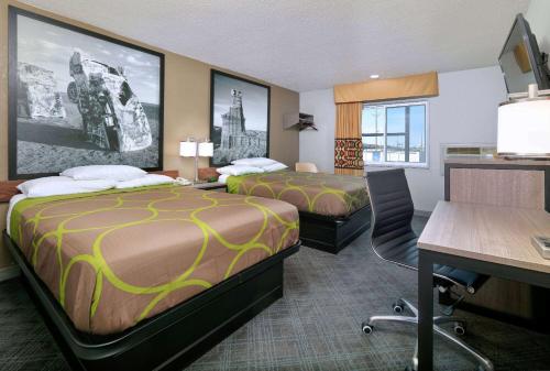 a hotel room with two beds and a desk at Super 8 by Wyndham Amarillo in Amarillo