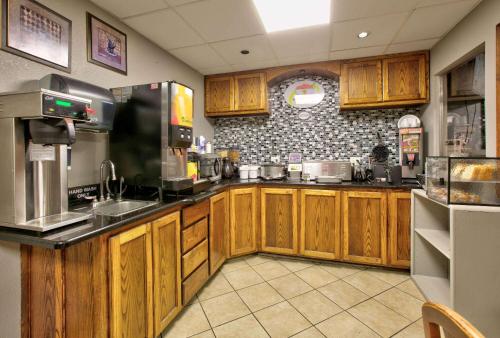 a kitchen with wooden cabinets and a counter top at Super 8 by Wyndham Amarillo in Amarillo