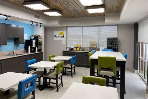 eine Cafeteria mit Tischen und Stühlen und eine Küche in der Unterkunft Days Inn & Suites by Wyndham Ridgeland in Ridgeland