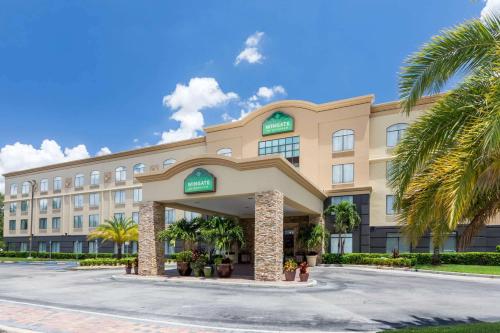 un hotel con palme di fronte a un edificio di Wingate by Wyndham - Universal Studios and Convention Center a Orlando