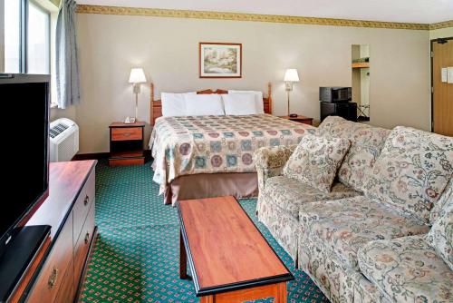 une chambre d'hôtel avec un lit et un canapé dans l'établissement Super 8 by Wyndham Omaha Eppley Airport/Carter Lake, à Omaha