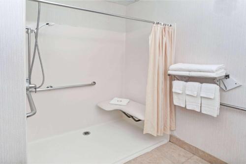 ein Bad mit einer Dusche und weißen Handtüchern in der Unterkunft Red Lion Inn & Suites Elk Grove Village in Elk Grove Village