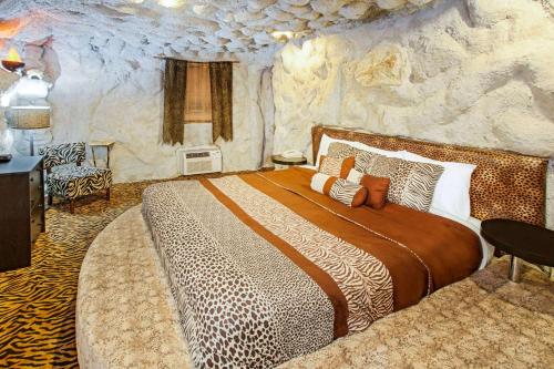 a bedroom with a large bed in a stone wall at Days Inn & Suites by Wyndham Terre Haute in Terre Haute