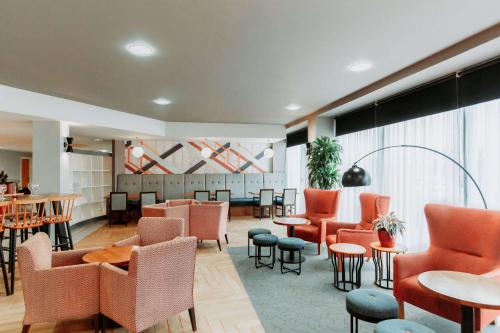 a waiting room with chairs and tables and a waiting area at Ramada Encore Newcastle-Gateshead in Newcastle upon Tyne