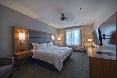 a hotel room with a bed and a flat screen tv at Wingate by Wyndham Houston Bush Intercontinental Airport in Houston