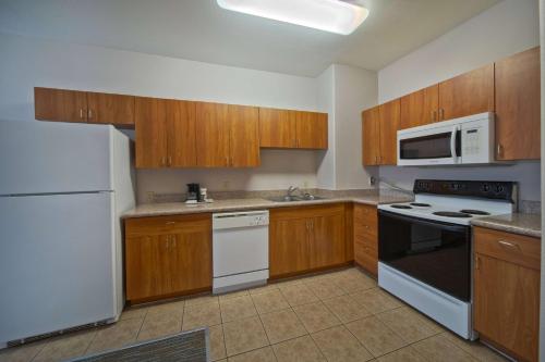 a kitchen with white appliances and wooden cabinets at Wingate by Wyndham Houston Bush Intercontinental Airport in Houston