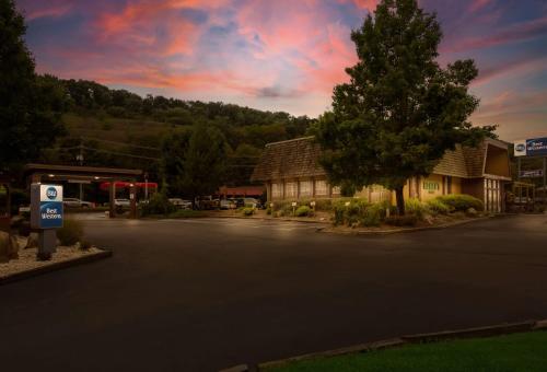 a parking lot with a gas station and a tree at Best Western Braddock Inn in La Vale