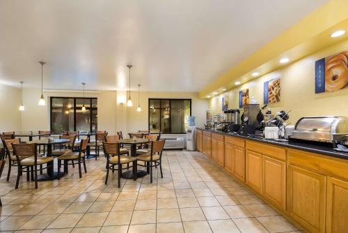 a restaurant with tables and chairs and a bar at Best Western Braddock Inn in La Vale