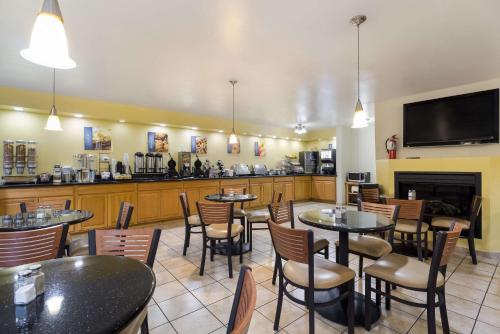 a restaurant with tables and chairs and a fireplace at Best Western Braddock Inn in La Vale