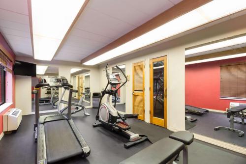 a gym with several tread machines in a room at Best Western Braddock Inn in La Vale
