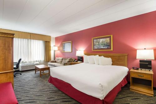 une chambre d'hôtel avec un grand lit et un salon dans l'établissement Best Western Braddock Inn, à La Vale