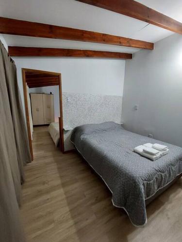 1 dormitorio con 1 cama con 2 toallas en Lourdes host en Ushuaia