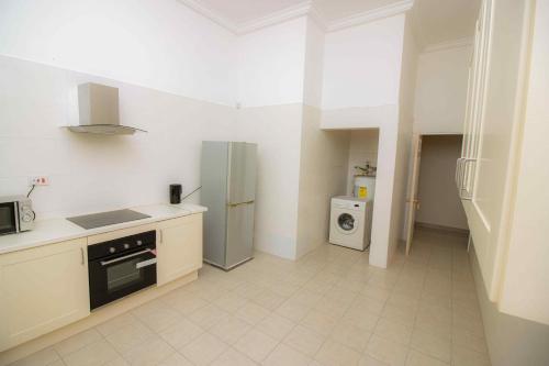 a kitchen with a refrigerator and a stove top oven at Brown Hills Residences in Aburi