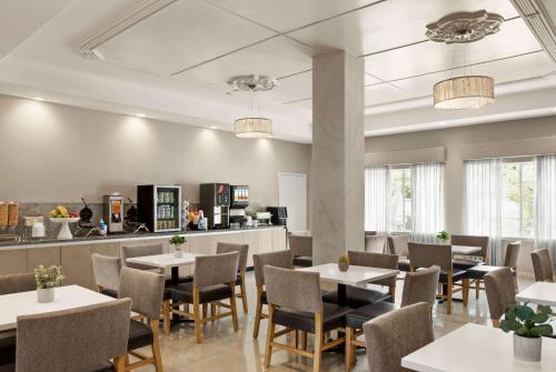 a restaurant with tables and chairs and a counter at La Quinta by Wyndham Brownsville North in Brownsville