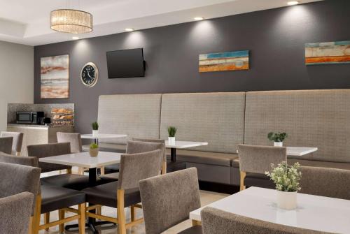 a restaurant with tables and chairs and a tv on a wall at La Quinta by Wyndham Brownsville North in Brownsville