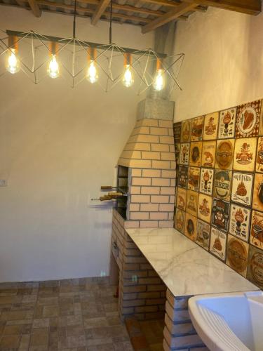 una cocina con horno de ladrillo y luces en Casa em Bertioga condomínio 250 metros da praia, en Bertioga