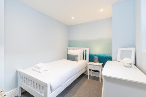 a white bedroom with two beds and a mirror at The Bakery A Renovated Gem in Central Brighton in Brighton & Hove