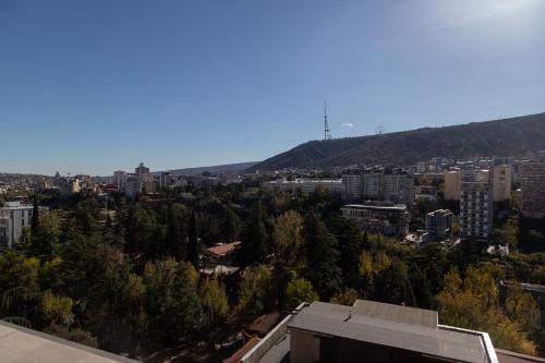 a view of a city with trees and buildings at Hotel Solum Roof Top in Tbilisi City