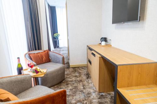 a living room with a couch and a tv in a room at Hotel Solum Roof Top in Tbilisi City