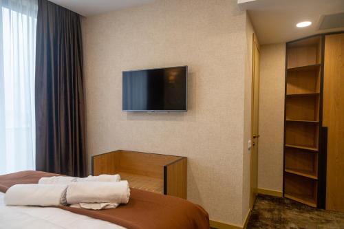 a hotel room with a bed and a tv on the wall at Hotel Solum Roof Top in Tbilisi City