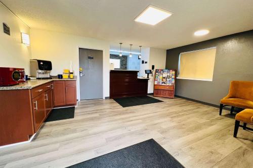 a large room with a kitchen with wooden floors at Super 8 by Wyndham Benton Harbor St Joseph in Benton Harbor