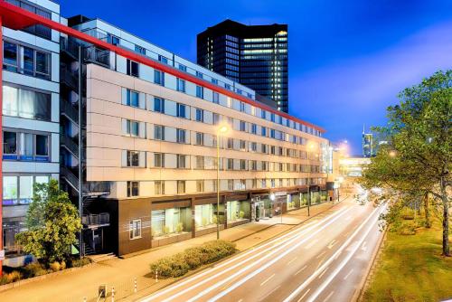 ein Apartmenthaus in der Nacht in einer Stadtstraße in der Unterkunft Ramada by Wyndham Essen in Essen