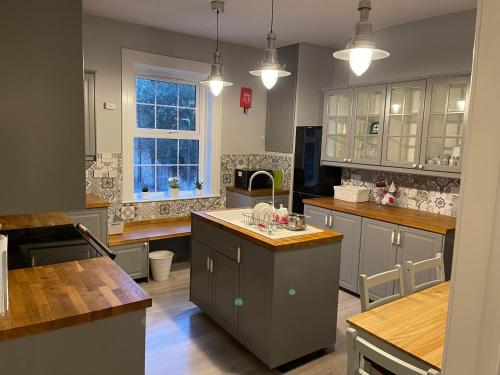 a large kitchen with gray cabinets and a window at Spacious 4-bed Holiday Home in the heart of Maidstone in Maidstone