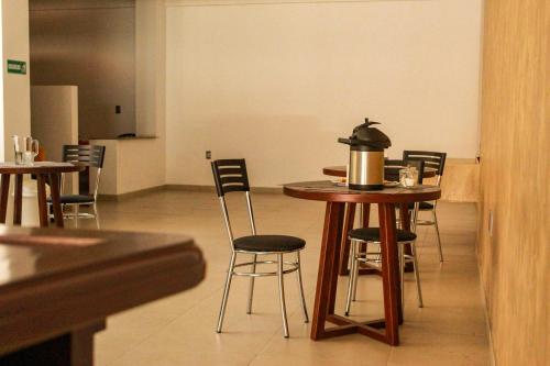 a table and chairs with a tea kettle on it at Hostal Sky in Tarija