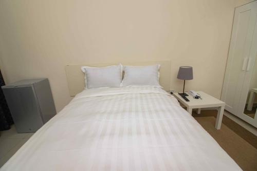 a large white bed in a room with a table at Brown Hills Residences in Aburi