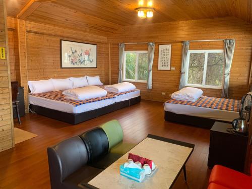 ein Zimmer mit 2 Betten und einem Sofa darin in der Unterkunft Tianen Farm in Hualing