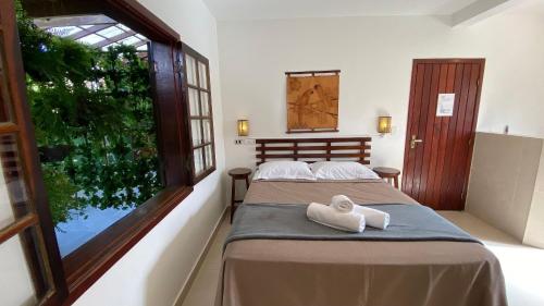 a bedroom with two beds and a window at Residencial Villa Cris - Jd. São Lourenço/Itaguaré in Bertioga