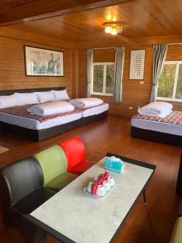 a room with two beds and a couch and a table at Tianen Farm in Hualing