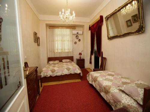 1 dormitorio con 2 camas y espejo en Leila, en Tiflis