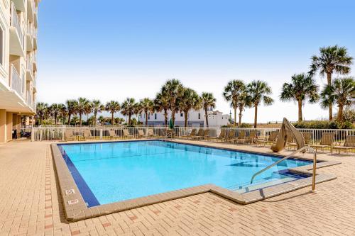 a large swimming pool with palm trees in the background at Destin on the Gulf in Destin