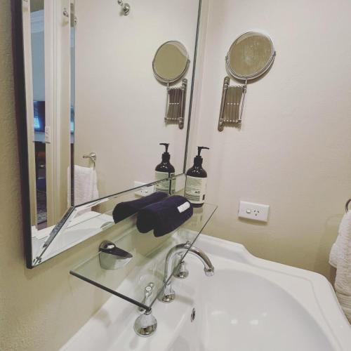 a bathroom with a sink and a mirror at Rowan Brae Historic Guesthouse in Blackheath