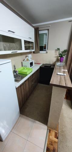 a small kitchen with a sink and a microwave at Fortress apartments Niš in Niš