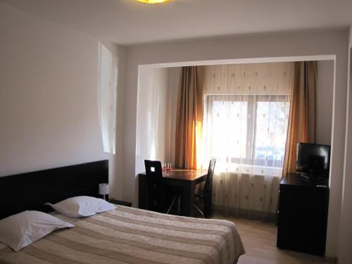 Un pat sau paturi într-o cameră la Hotel Silvia Apart Sinaia