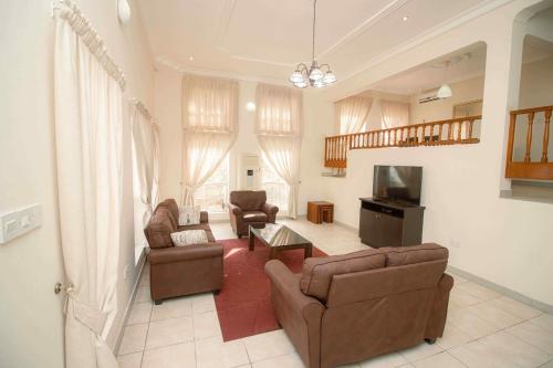 a living room with two couches and a television at Brown Hills Residences in Aburi