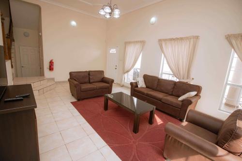 a living room with two couches and a table at Brown Hills Residences in Aburi